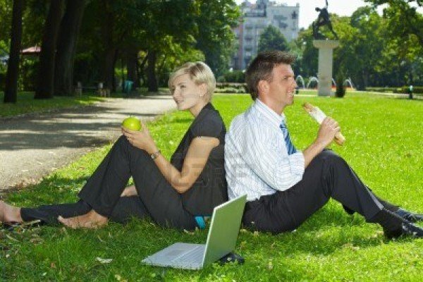 6220686-young-businesspeople-sitting-in-grass-and-having-lunch-in-a-park-summertime